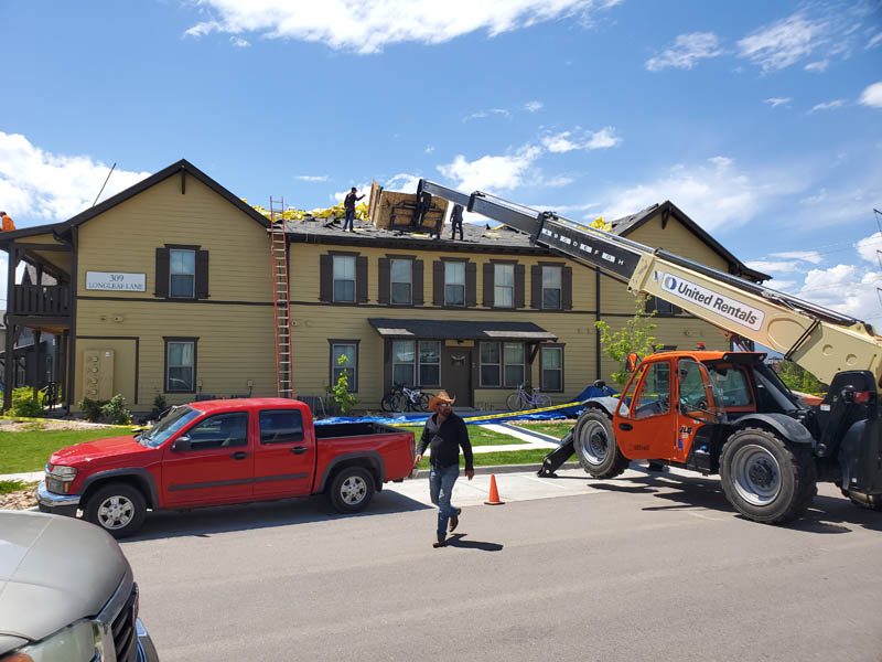 roof being loaded during a multi-family roof replacement by Custom exteriors