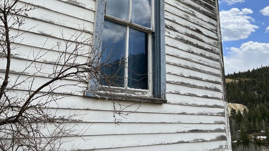 Signs you need to paint your home include peeling paint like this home that Custom Exteriors recently repainted