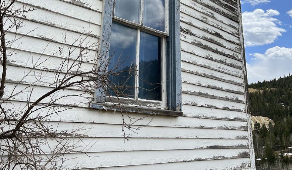 Signs you need to paint your home include peeling paint like this home that Custom Exteriors recently repainted