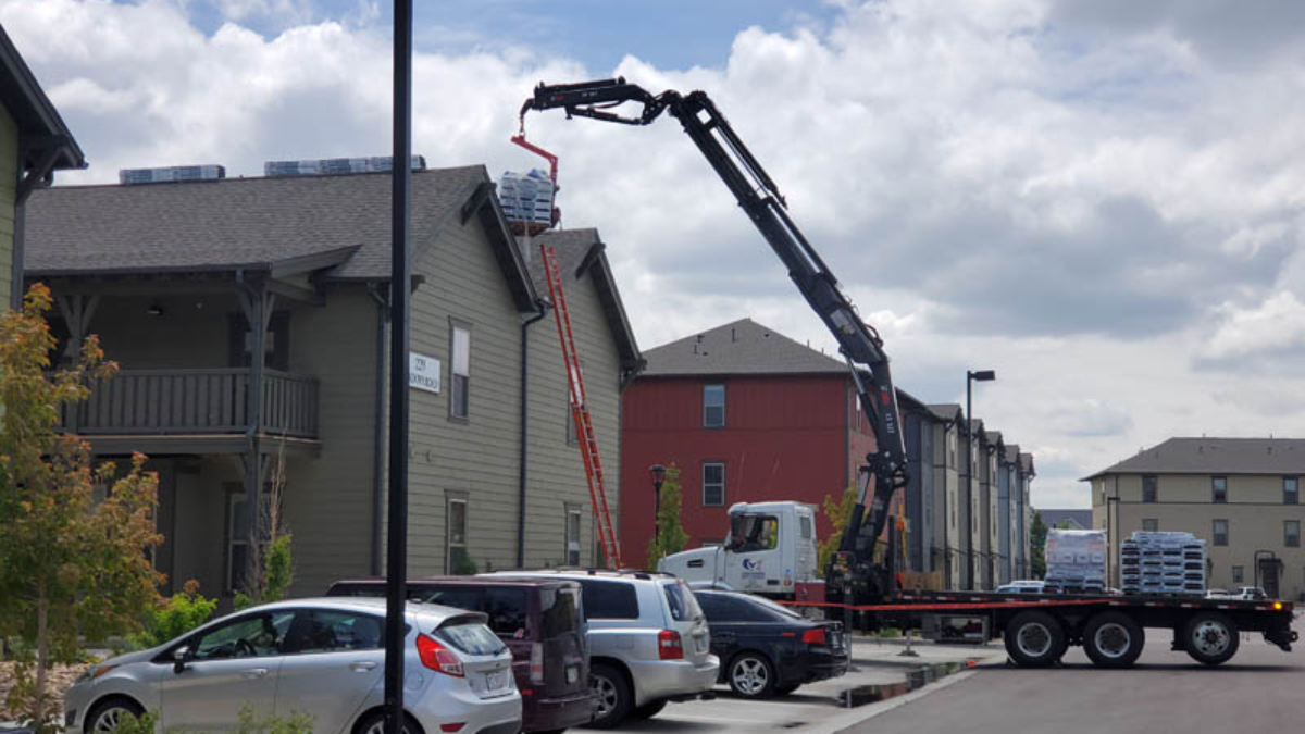 Exterior upgrades for rental properties showing a roof being replaced on a multi-family buidling