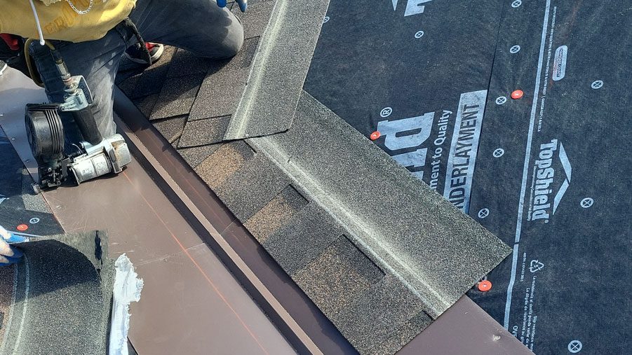 Valley metal being installed on a Northern Colorado roof replacement by Custom Exteriors, a residential exterior services company