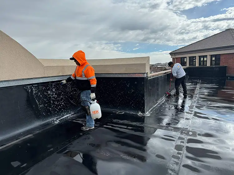 The commercial roofing team at Custom Exteriors is cleaning this commercial roof in Broomfield in preparation of the installation of a roof coating.