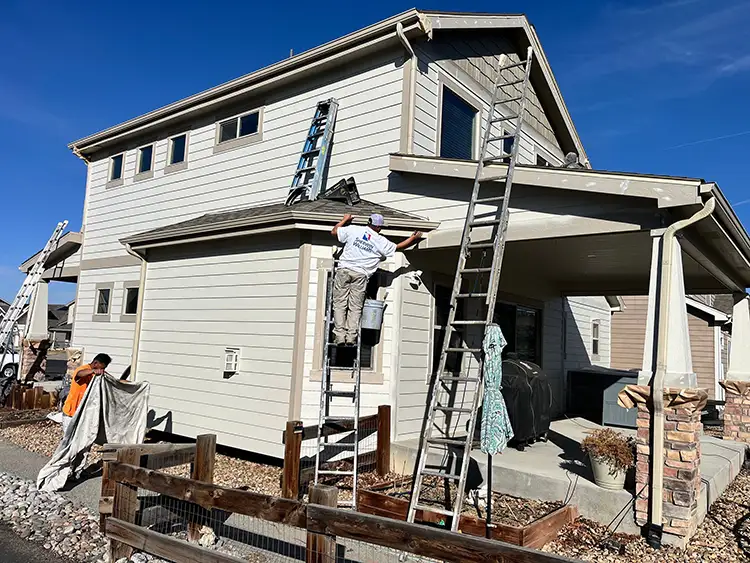 A Custom Exteriors painting crew painting a home in Greeley.